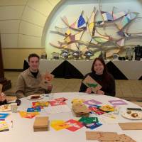 Three women and one man holding decorated lunch bags